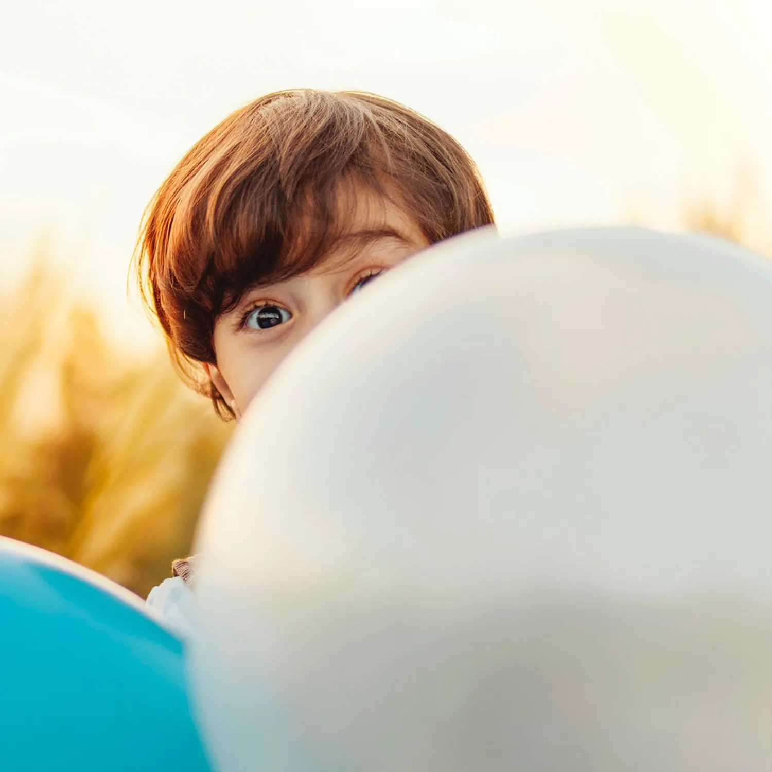 Kind ragt durch Luftballons